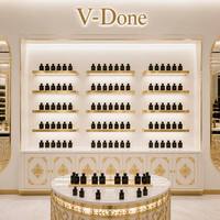 Vitrine de présentation de parfums sur mesure avec cadre doré, éclairage LED, comptoir îlot rond pour boutique de cosmétiques et de parfums