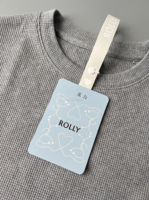 Étiquettes de vêtements anti-retour personnalisées imprimées sur papier synthétique blanc avec fermeture à pression et découpe de forme pour les marques de vêtements