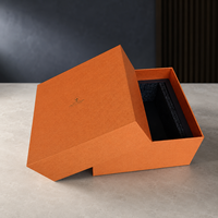 Boîte cadeau orange haut de gamme avec surface texturée premium, insert en mousse noire et construction en papier rigide durable