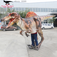 Costume réaliste de dinosaure marchant dans un parc à thème Performance sur scène