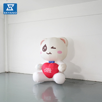 Modèle gonflable personnalisé d'ours blanc de dessin animé tenant un cœur pour la publicité et la décoration d'événements en plein air