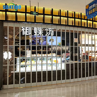 Vente en gros de porte électrique en alliage d'aluminium pour l'intérieur, avec volet roulant en cristal, porte coulissante pliable pour centre commercial, fabricant