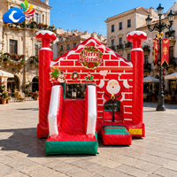 Château gonflable de Noël avec mur de briques et toboggan pour enfants, idéal pour les événements et fêtes de fin d'année à louer