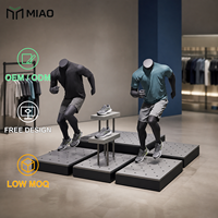 Ensemble de présentoirs pour mannequins de vêtements de sport avec bords en métal noir et plateformes perforées grises pour les sols de magasin
