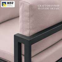 Canapé d'angle extérieur en forme de L avec structure en métal noir et coussins rose poudré, mobilier de jardin