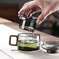 Tasse à thé en verre gris fumé avec poignée en bois et infuseur à couvercle pour la préparation du thé à la maison ou au bureau