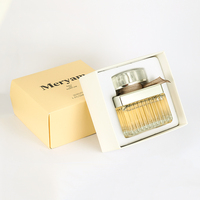 Perfume Femenino en Envase Rectangular de Vidrio con Franjas Plateadas, Lazo de Cinta Marrón, Tapa Dorada y Caja Dorada. Aroma Atemporal para Aniversario.