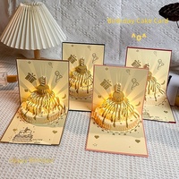 Carte d'anniversaire populaire en gros, carte de vœux 3D pop-up musicale LED en papier artistique avec feuille d'or, design gâteau, pour fête d'anniversaire