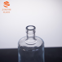 Bouteille en verre cylindrique de 500 ml avec logo goutte d'eau en relief, idéale pour l'emballage du gin, de la vodka et du whisky
