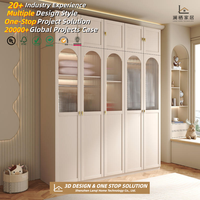 Armoire complète moderne et minimaliste blanche avec portes sans poignées et éclairage LED, menuiserie sur mesure pour les constructeurs de maisons aux États-Unis