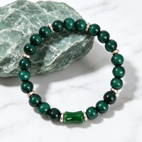 Bracelet de luxe en perles rondes de huit millimètres couleur émeraude, avec centre en forme de baril et entretoises dorées, en jade vert