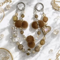 Chaîne de téléphone de luxe en fausse fourrure en forme de cœur, perles de cristal, strass, porte-clés doré, breloque de sac, pompon, bijoux faits à la main, vente en gros