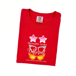 Camiseta de Mujer Comfort Colors, Roja, Cuello Redondo, Manga Corta, 100% Algodón, Estampado 'Strength Looks Different' para el Día Internacional de la Mujer - Product Image 1