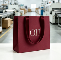 Sac shopping en papier bordeaux premium avec logo estampé à chaud et poignée en ruban, personnalisé pour l'emballage cadeau de marques de luxe