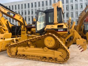 Bouteur sur chenilles Caterpillar D5M d'occasion à prix abordable, avec ripper robuste, haute efficacité pour les travaux de terrassement, pièces détachées faciles à trouver. - Product Image 1