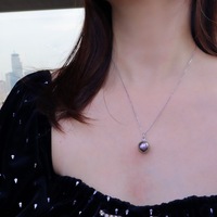 Mesdames à la mode portant un collier pendentif en diamant en or 18 carats avec perle noire de Tahiti
