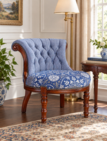 Fauteuil capitonné antique avec dossier à carreaux bleus et blancs, assise à motif floral, garniture à clous et pieds tournés sculptés