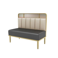 Banquette de restaurant confortable et légère en cuir gris à dossier haut, base de table basse dorée et chaise de restaurant blanche