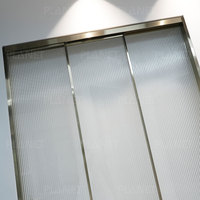 Porte coulissante simple en verre trempé sur mesure pour salle de bain, avec cadre doré, en verre cannelé contemporain, servant également de séparateur de pièce