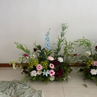 Bruiloft entree decoratie, bloemstukken met wilde bloemen in natuurlijk ogende, hoogwaardige bloemen en groen.