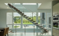 Rampe d'escalier flottante Tanlong moderne en bois dur avec structure centrale et balustrade en verre sans cadre