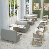 Ensemble de mobilier moderne pour restaurant et café : banquette rose, chaises en métal doré et table en marbre avec sièges banquetaux