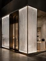 Façade en verre décorative encadrée de profilés en acier inoxydable sur mesure pour devanture de magasin de luxe