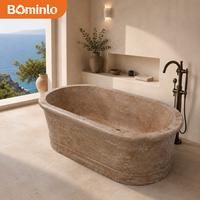 Baignoire autoportante ovale en travertin méditerranéen beige texturé avec rebord évasé et base étagée pour villa côtière