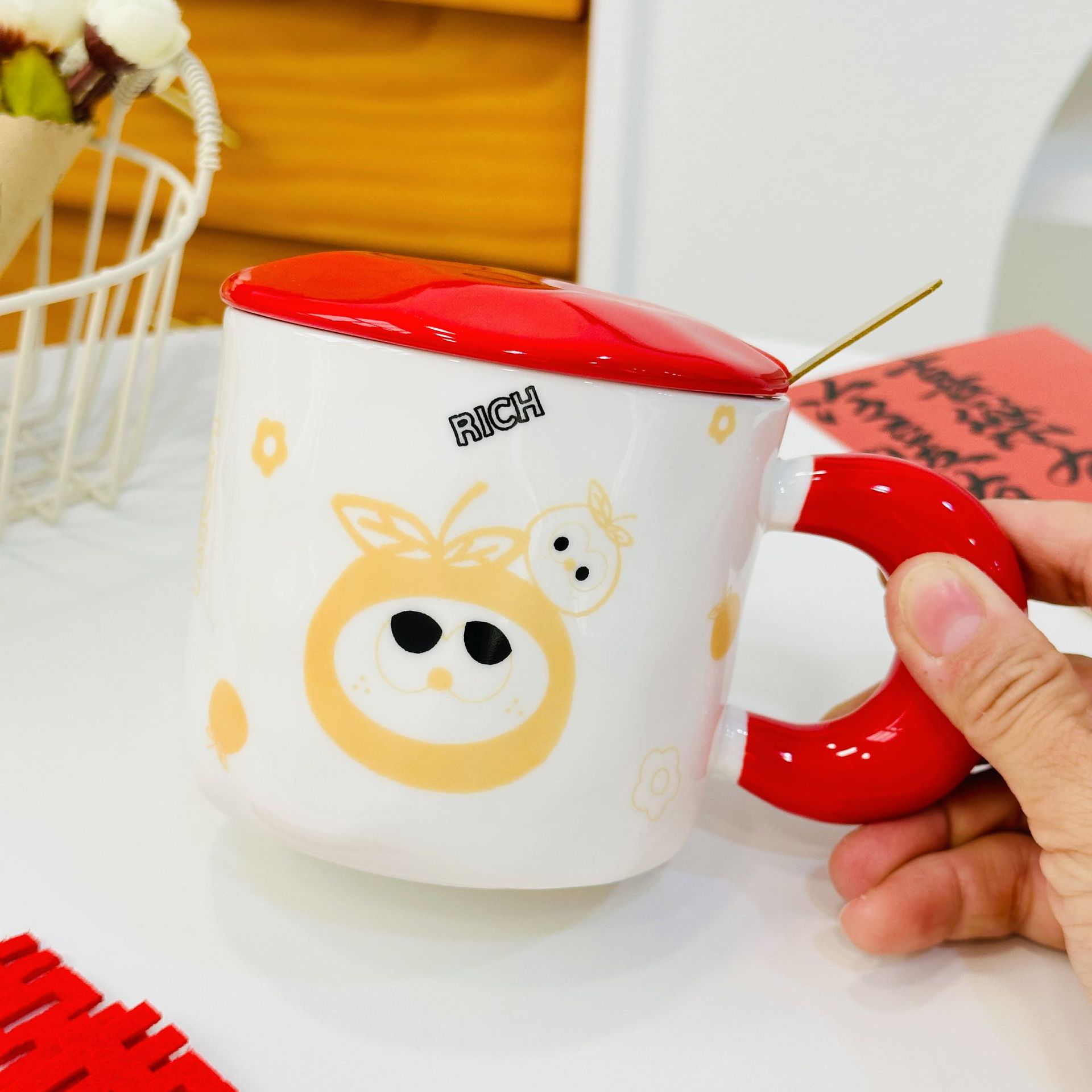 Taza de cerámica roja anaranjada superior derecha con la tapa y la cuchara
