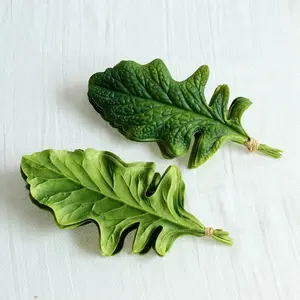 Искусственные зеленые листья искусственной хризантемы на ощупь