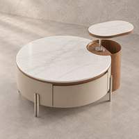 Table basse relevable WYRAX pour hall d'hôtel avec plateau supérieur surélevé, plateau latéral ouvert et base de rangement incurvée