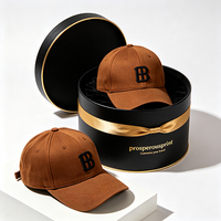 Boîte cadeau rigide ronde noire personnalisée avec ruban doré et doublure en velours pour casquette de baseball