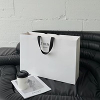 Sac fourre-tout en papier biodégradable blanc crème de luxe avec logo personnalisé, laminage mat, large ruban pour boutique de vêtements et de chaussures
