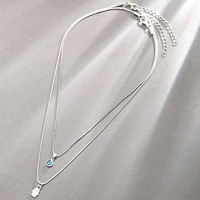 Le nouveau collier double couche à pendentif œil turc rétro et palmier 2025 est un accessoire unique, polyvalent et haut de gamme