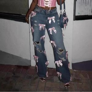 กางเกงยีนส์สตรีสไตล์วินเทจดีไซน์ใหม่ขายส่ง ผ้าฝ้าย 100% ล้างสีแบบแอซิด แต่งรอยขาด ปะโบว์ ทรงหลวม - Product Image 1