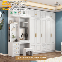 Armoire complète moderne et minimaliste blanche avec portes sans poignées et éclairage LED, menuiserie sur mesure pour les constructeurs de maisons aux États-Unis