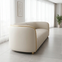 Canapé en cuir côtelé crème avec garniture en métal doré, canapé moderne minimaliste lumineux pour salon ensoleillé