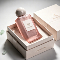 Flacon de parfum vide rectangulaire long givré bleu brumeux à paillettes, avec bouchon boule rose nude, plaque nominative blanche, logo personnalisé et coffret cadeau