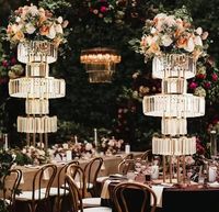 Grand lustre moderne en métal doré avec cristaux, support de fleurs et candélabre pour centre de table de mariage 2026