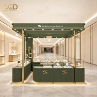Kiosque de présentation pour bijouterie, panneau en bois vert, cadre en métal doré, éclairage LED, verre trempé pour boutique de centre commercial, magasin éphémère