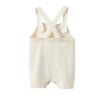 Combinaison bébé en coton pur minimaliste, tricotée, avec détail cœur ajouré, bretelles croisées, sans manches