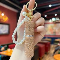 Mini flacon de parfum portable populaire incrusté de diamants, porte-clés avec chaîne de perles et strass, vaporisateur à pression pour accessoire de sac féminin