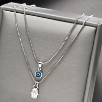Le nouveau collier double couche à pendentif œil turc rétro et palmier 2025 est un accessoire unique, polyvalent et haut de gamme