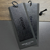 Étiquette personnalisée minimaliste pour vêtements masculins, en carton rigide noir parfumé aux herbes, avec logo estampé à chaud pour l'habillement de mode moderne