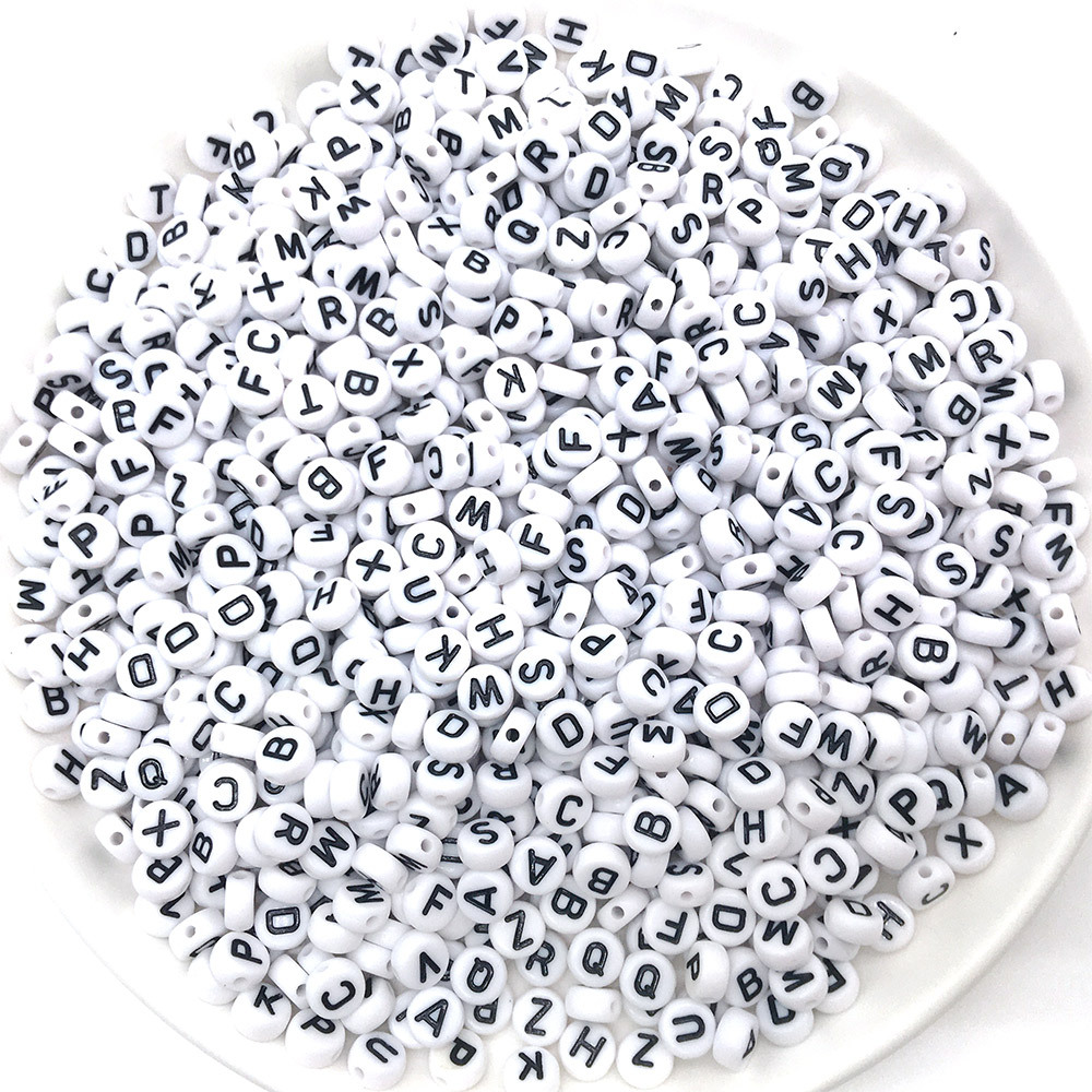 Rond-lettre noire avec des perles blanches