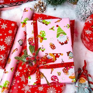 Papel de regalo navideño de doble cara con diseño de Papá Noel, gnomos y copos de nieve en colores rosa y rojo, en papel estampado. - Product Image 3