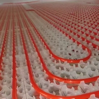 Cinq raccords fixes du système de climatisation à source géothermique soutiennent uniformément les conduites de chauffage sous le plancher.