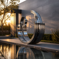 Sculpture d'anneau creux en acier inoxydable poli effet miroir, au design moderne et élégant, pour espaces extérieurs tels que parcs et places publiques