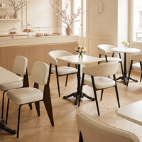 Tables blanches de style minimaliste et chaises rembourrées douces, mobilier commercial pour pâtisserie et café