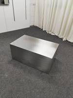 Table basse minimaliste en acier inoxydable pour petit espace de vie, avec finition mate brossée.